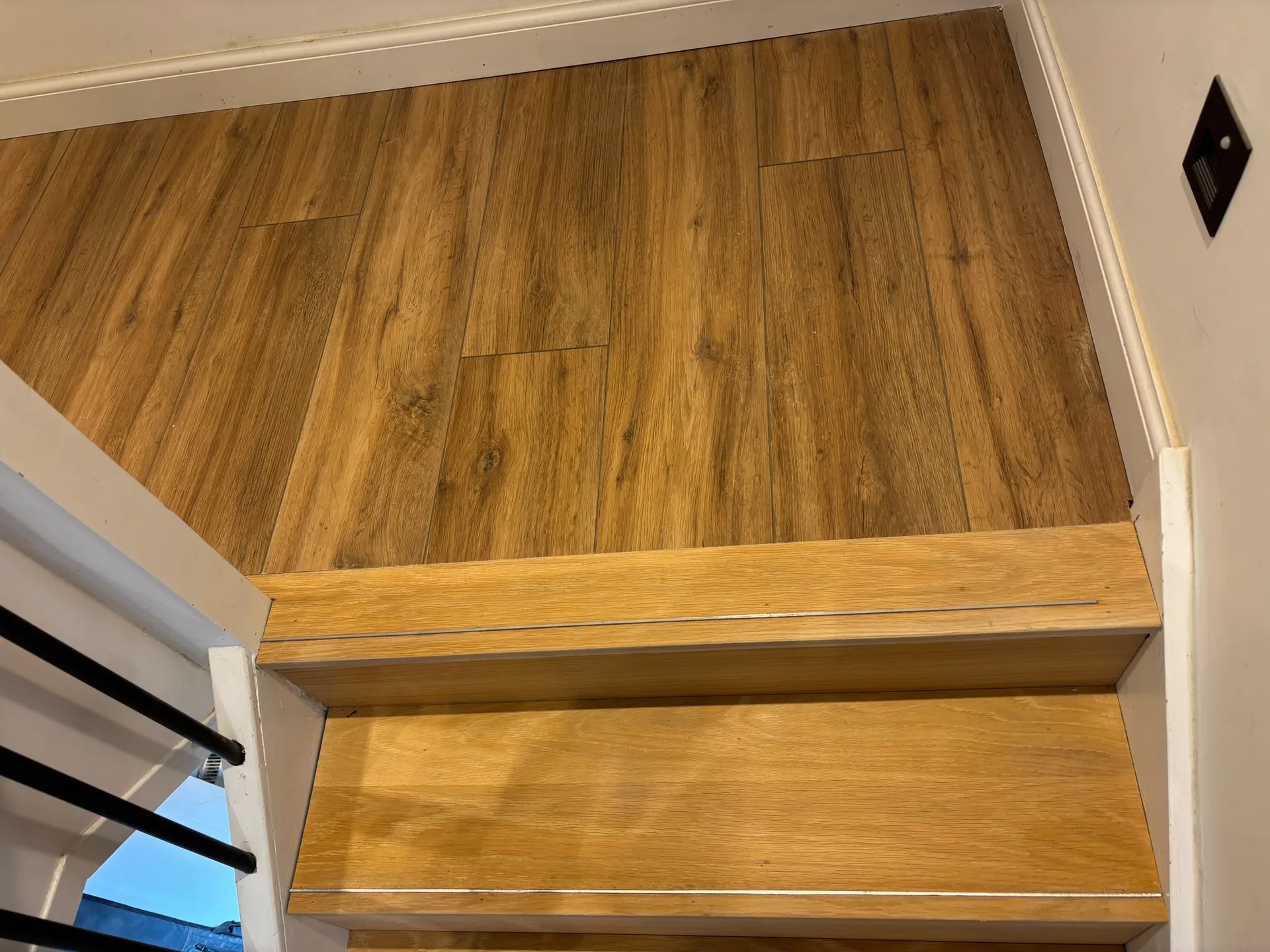 Modern wooden staircase with white walls