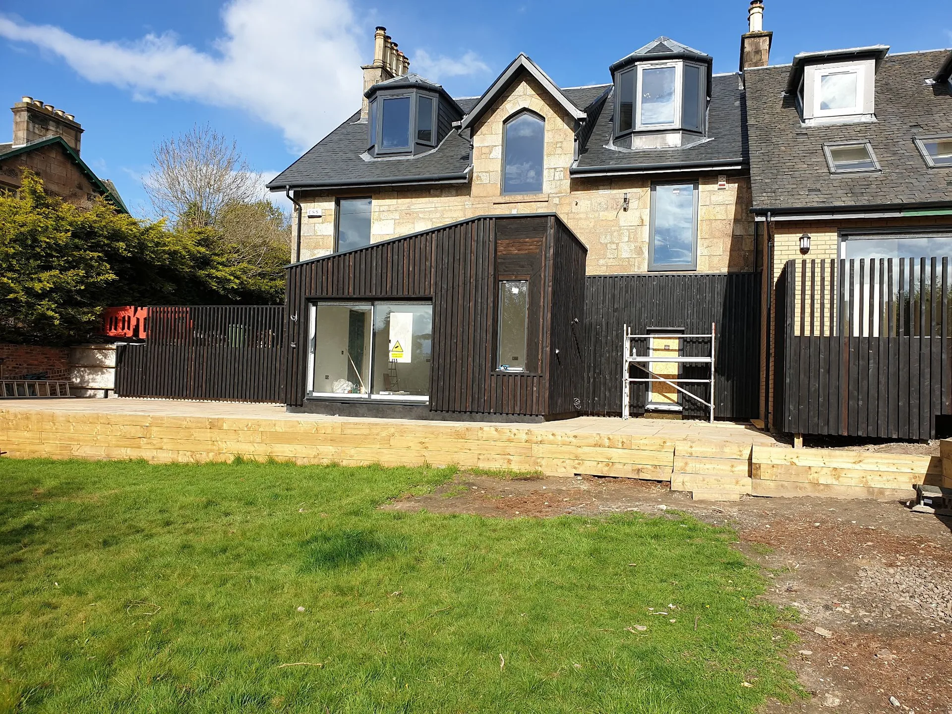Modern dark-clad extension on traditional stone home