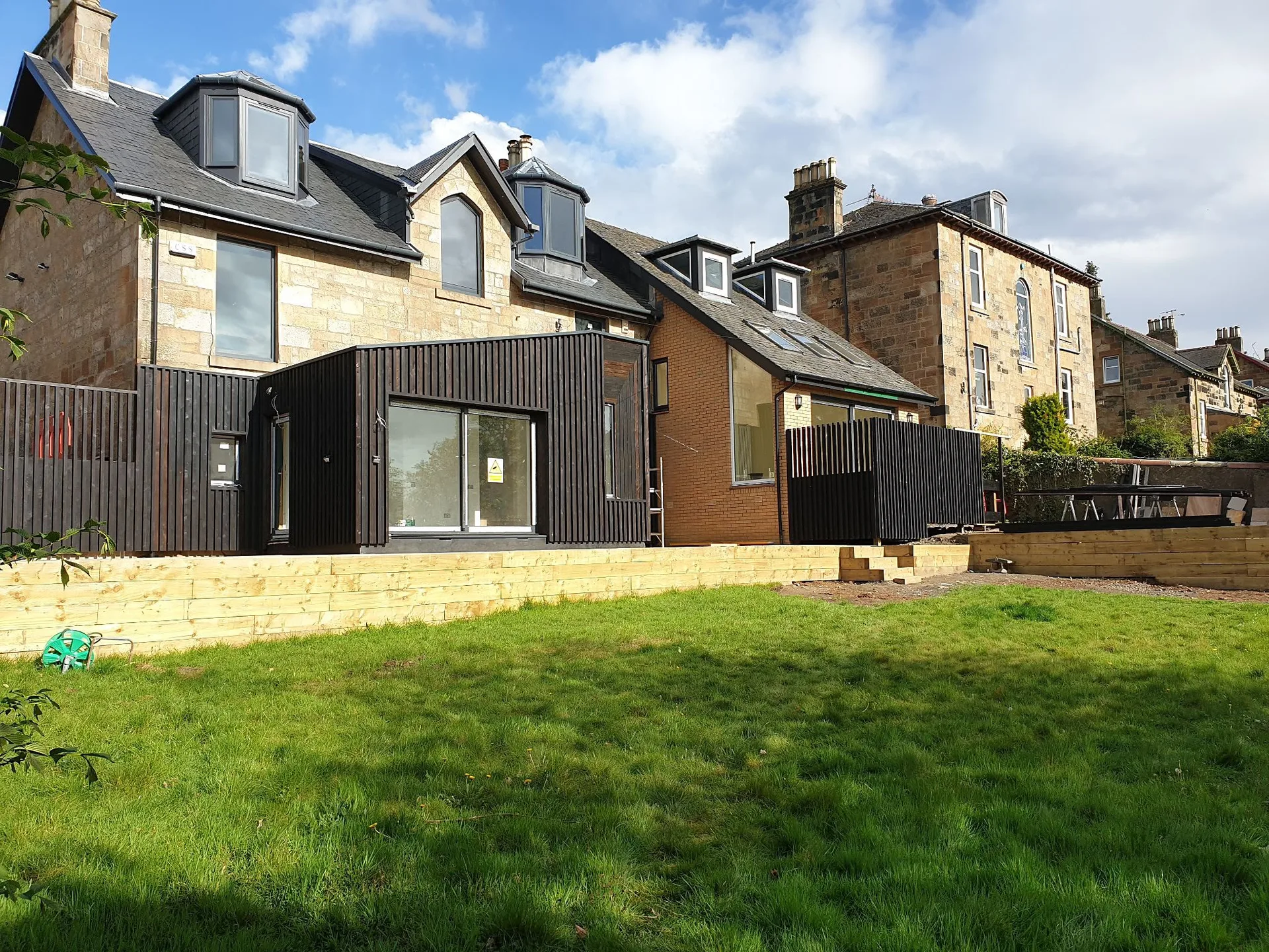 Modern black extension added to stone cottage