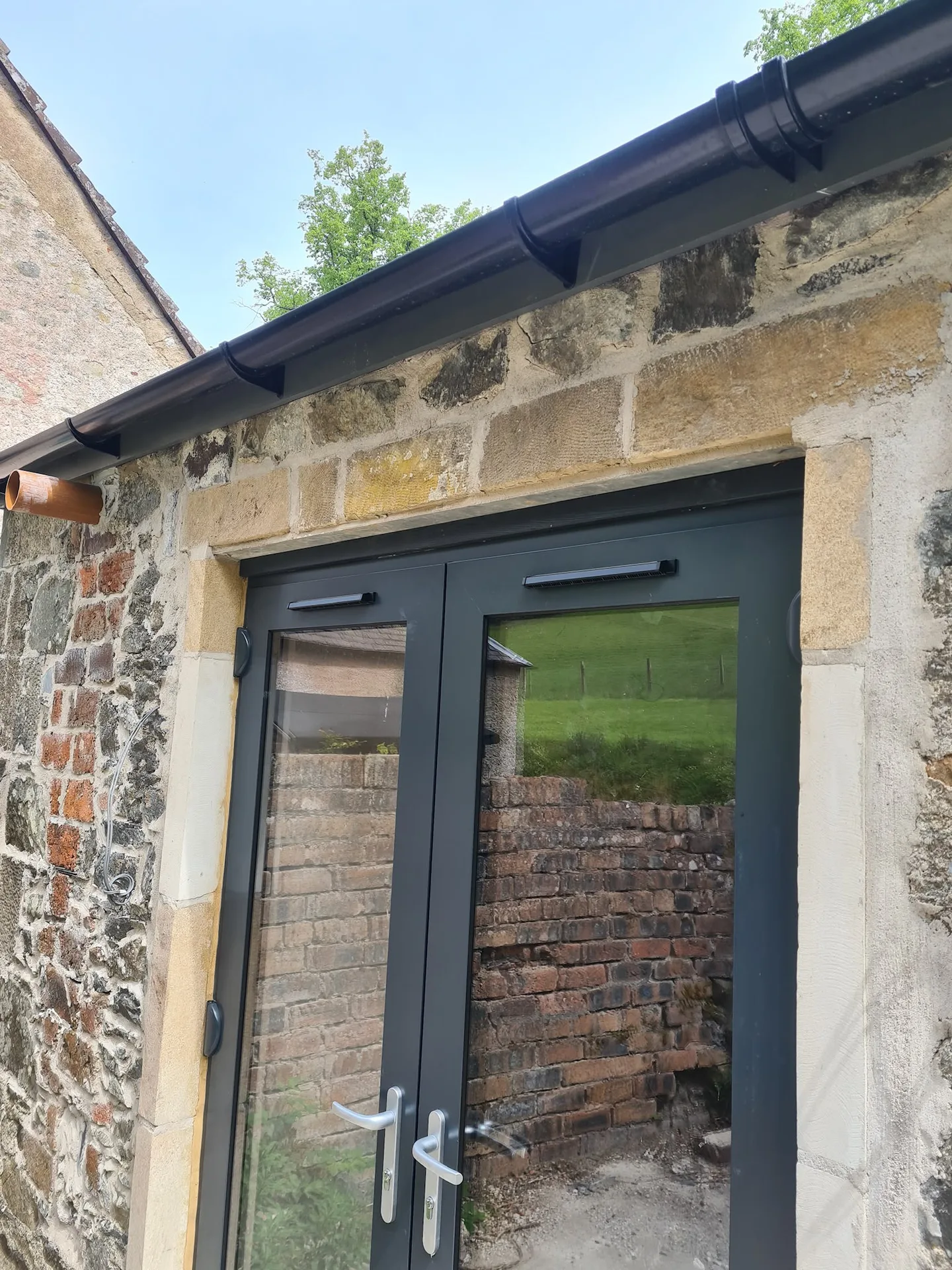 Modern glass door on historic stone facade