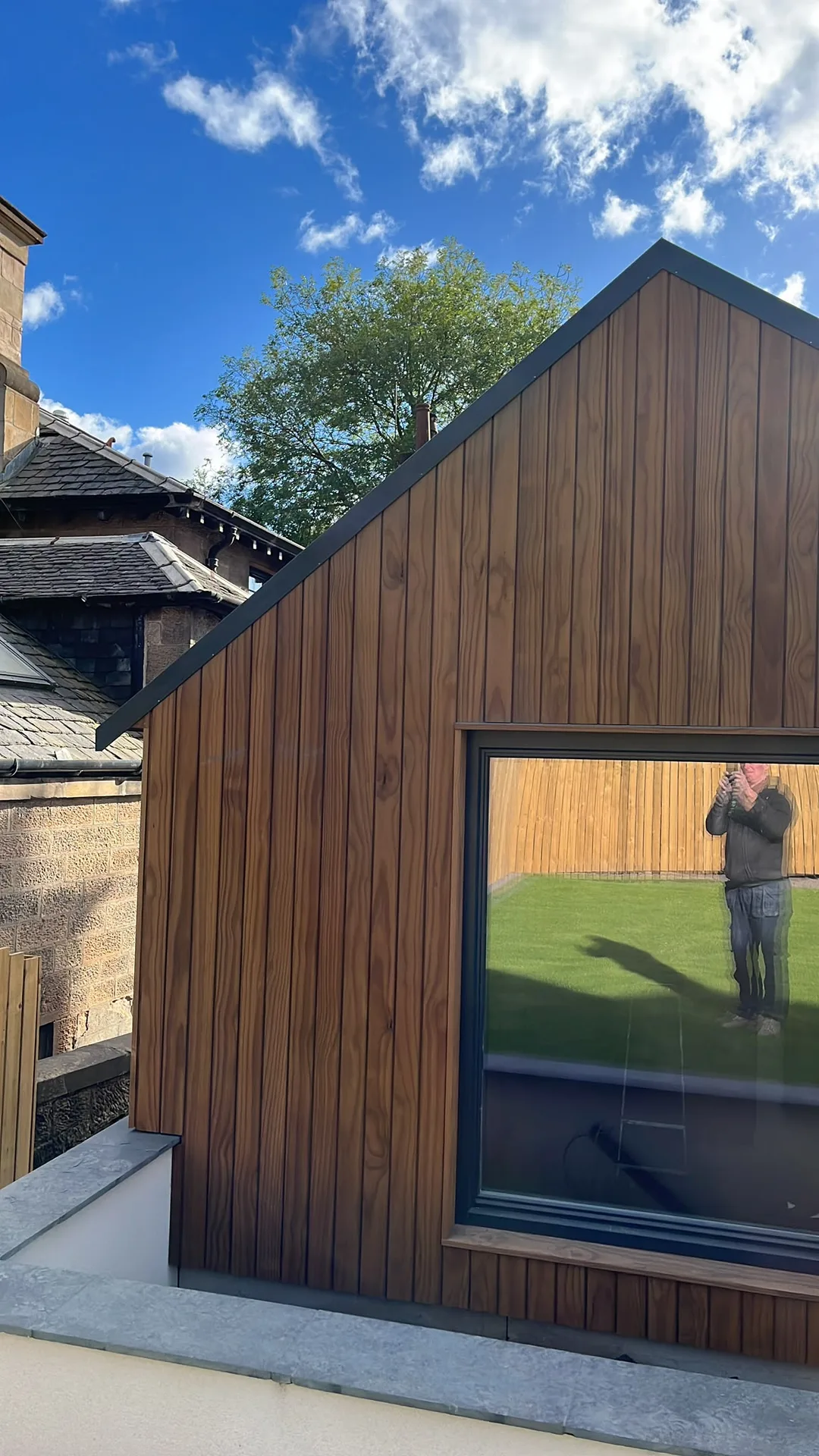 Modern timber-clad building extension with large window