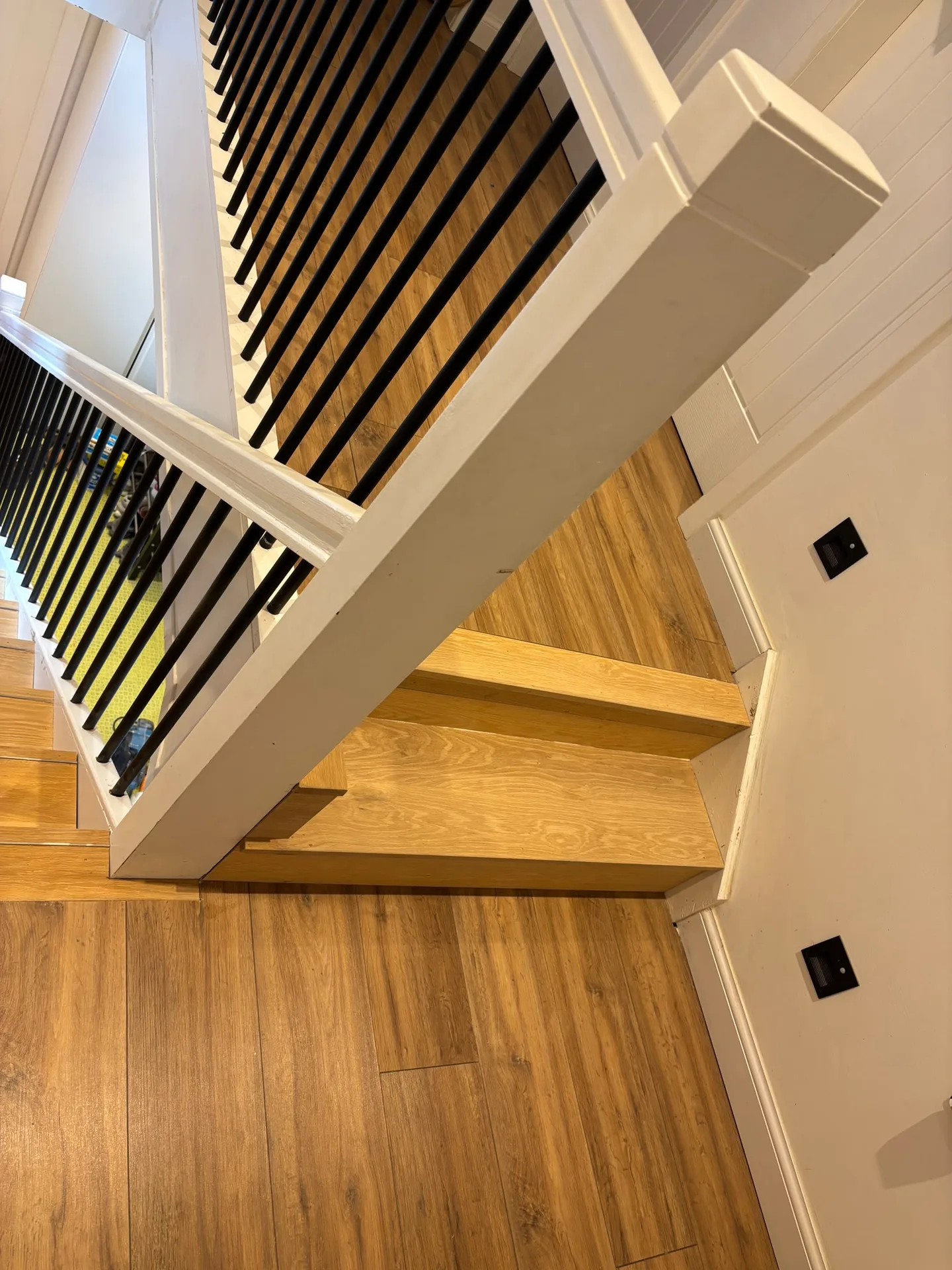 Modern wooden staircase with black metal railings