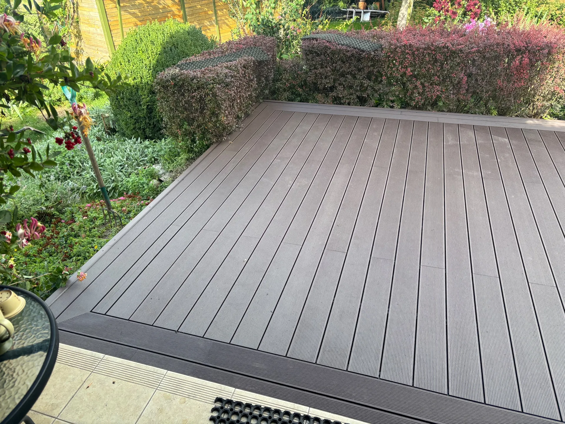 Modern composite deck with manicured garden borders