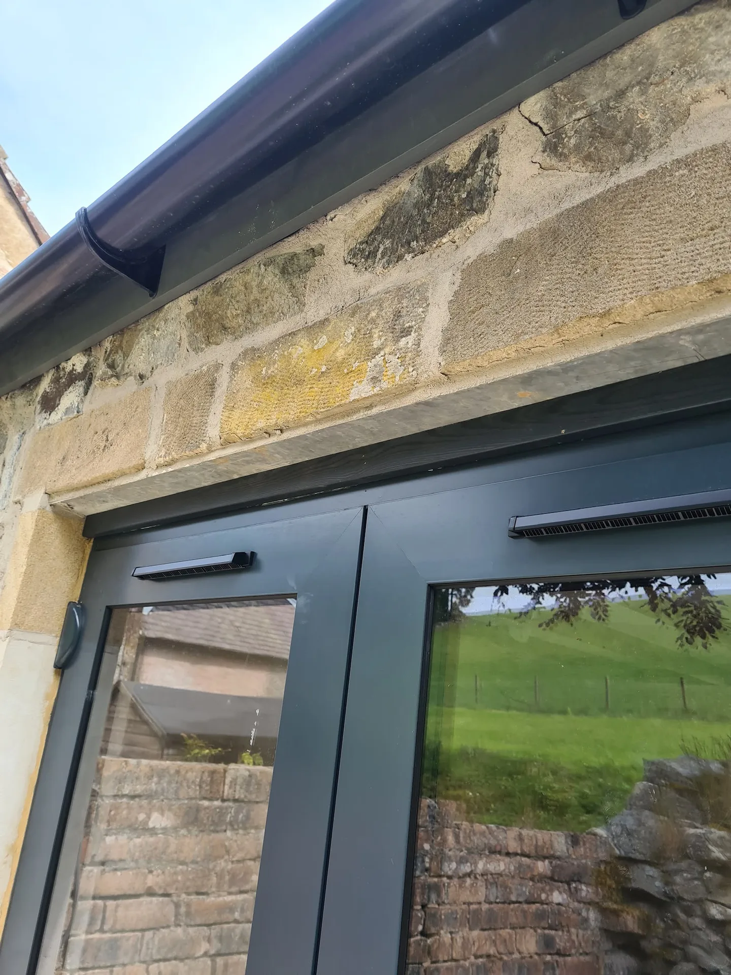 Stone building renovation with modern black windows