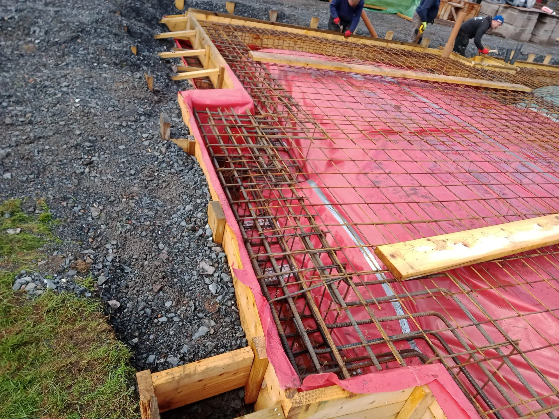 Construction foundation with red rebar reinforcement