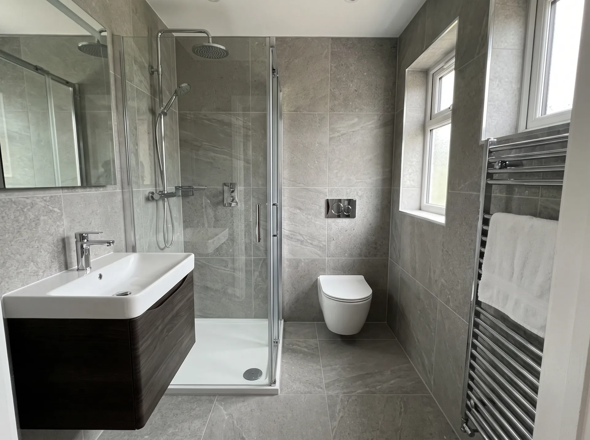 Modern bathroom with white marble-effect wall tiles, glass shower enclosure, and contemporary sink with dark vanity unit