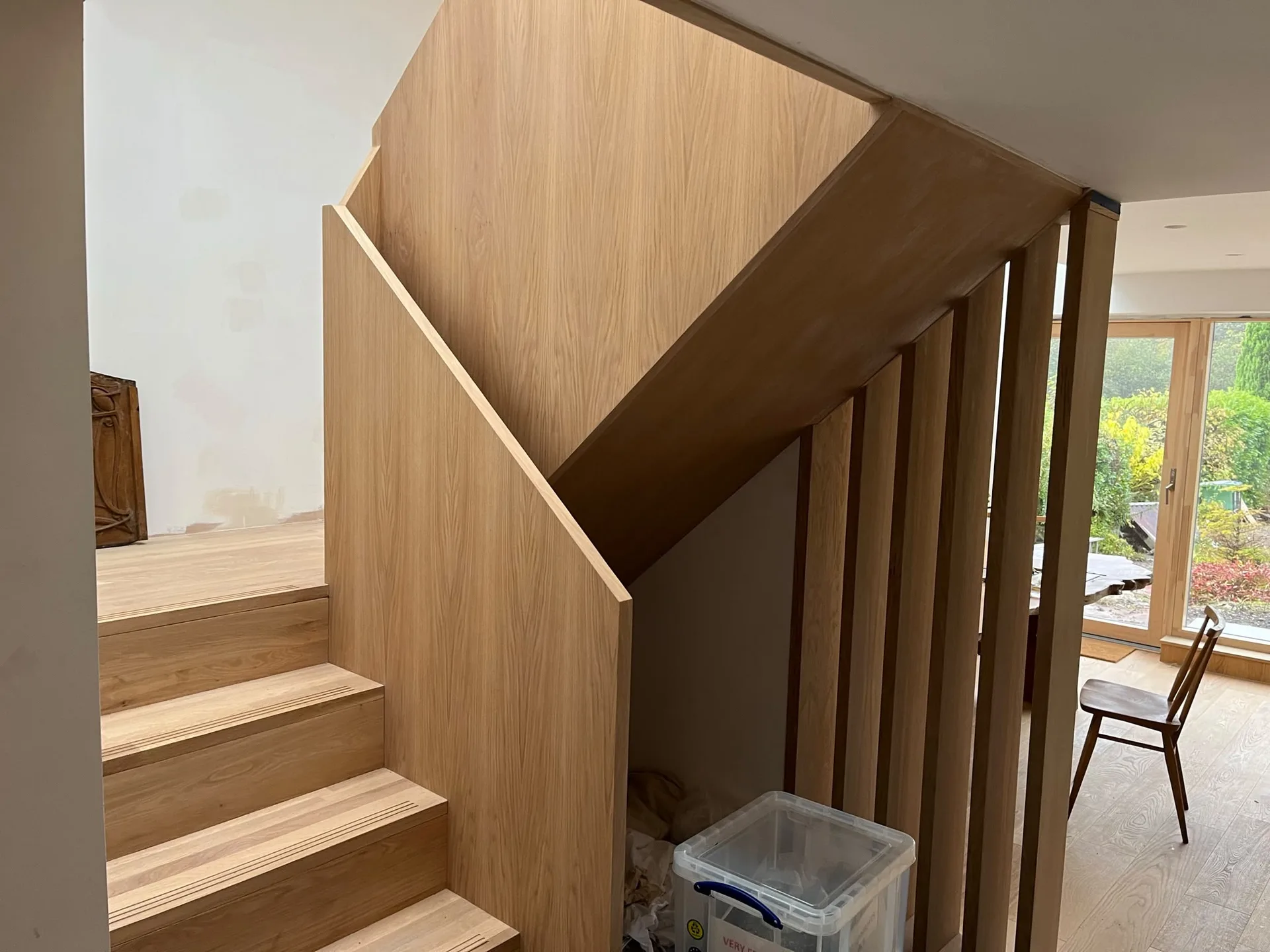 Custom wooden staircase with bespoke joinery cabinetry built under stairs in modern home interior