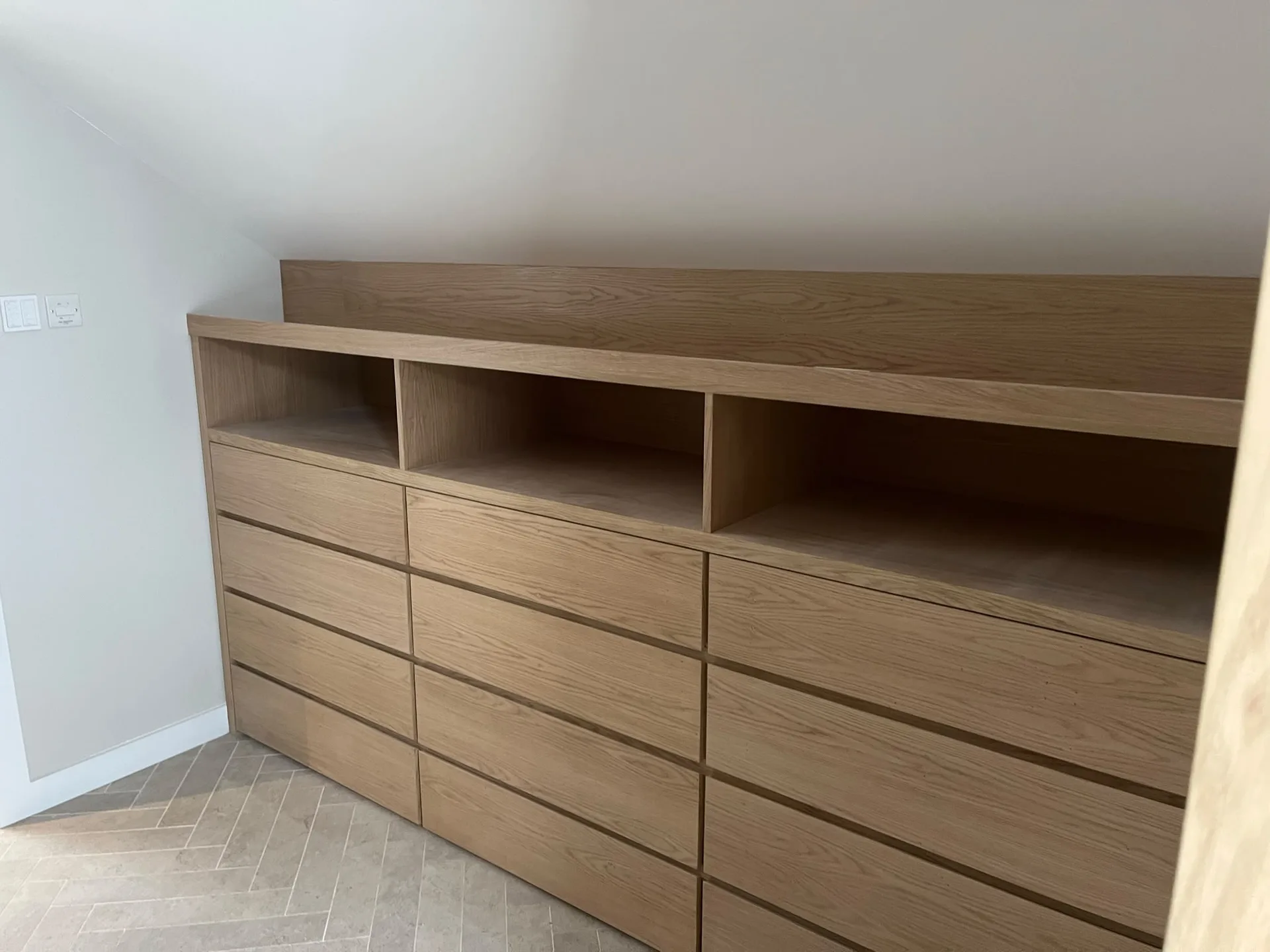 Bespoke joinery fitted furniture with custom wooden drawers and open shelving installed in modern bedroom