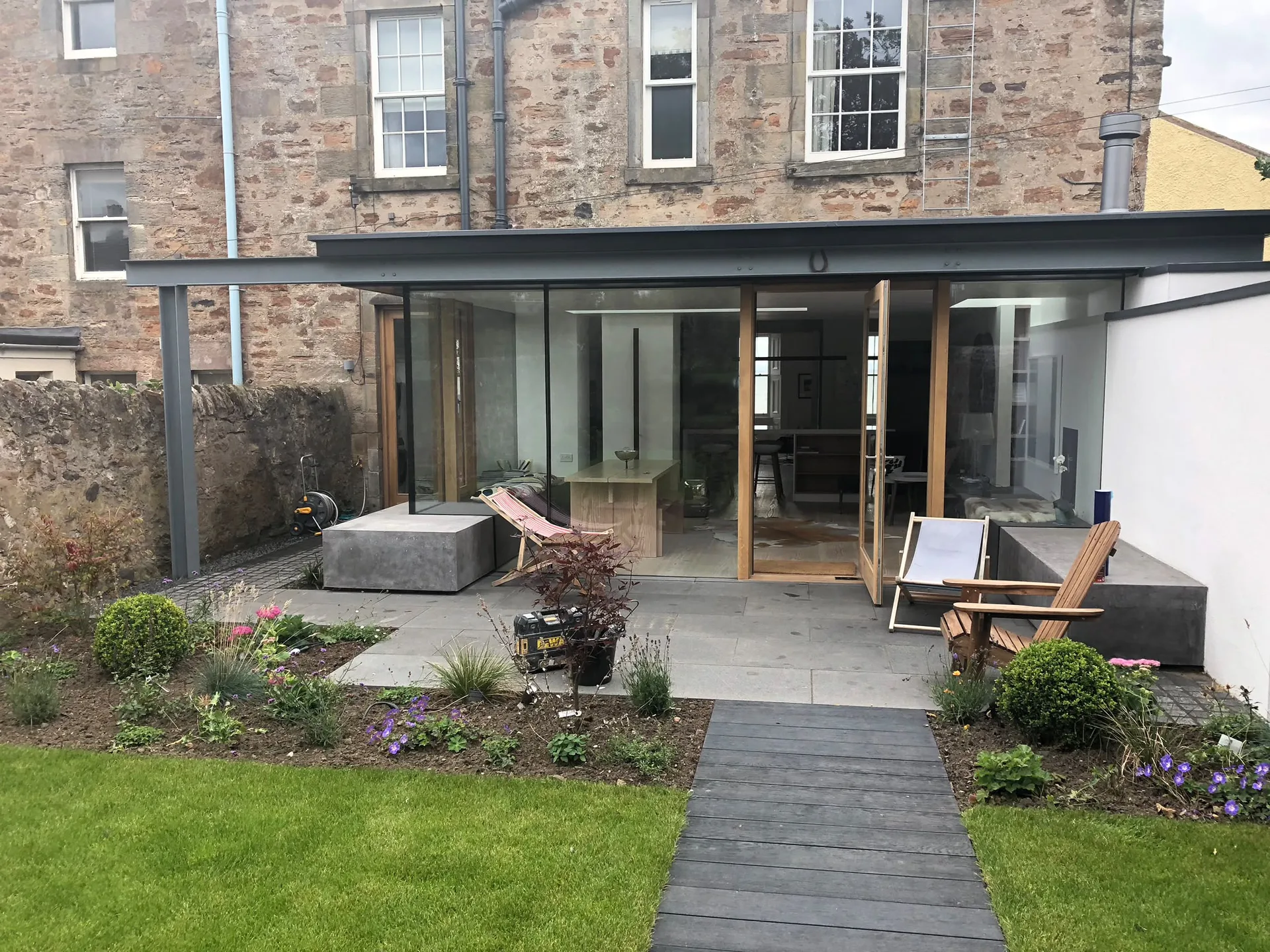House extension with glazed facade and timber frame addition to stone cottage
