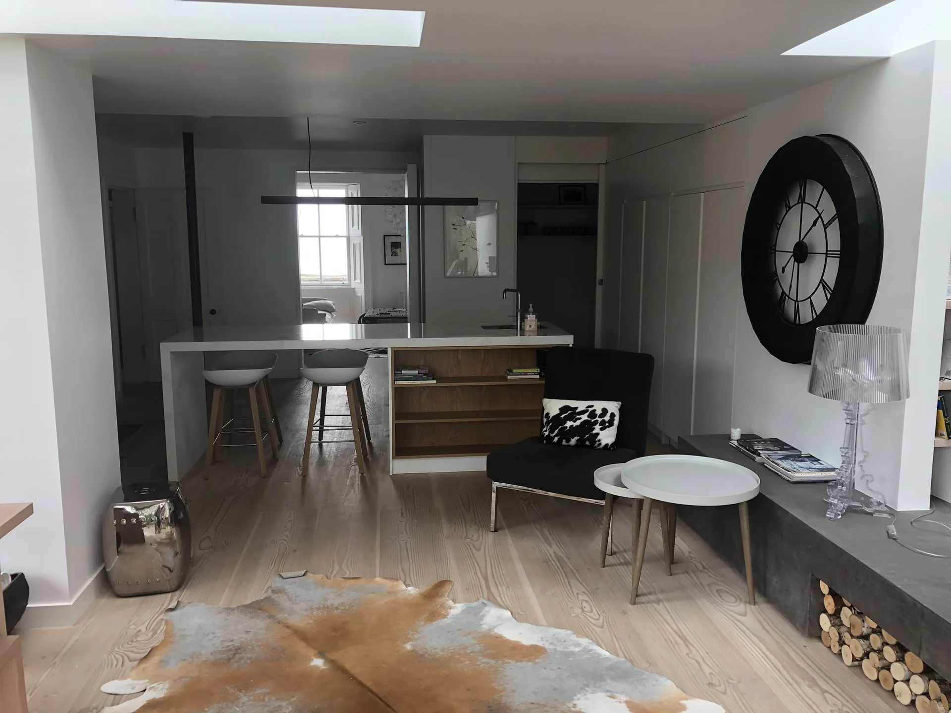 Modern open-plan kitchen and living room interior fit out with island seating and wood flooring