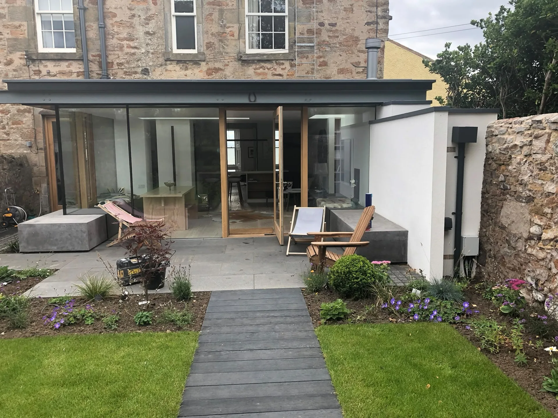 Modern House Extension with sliding glass doors, timber decking and garden landscaping