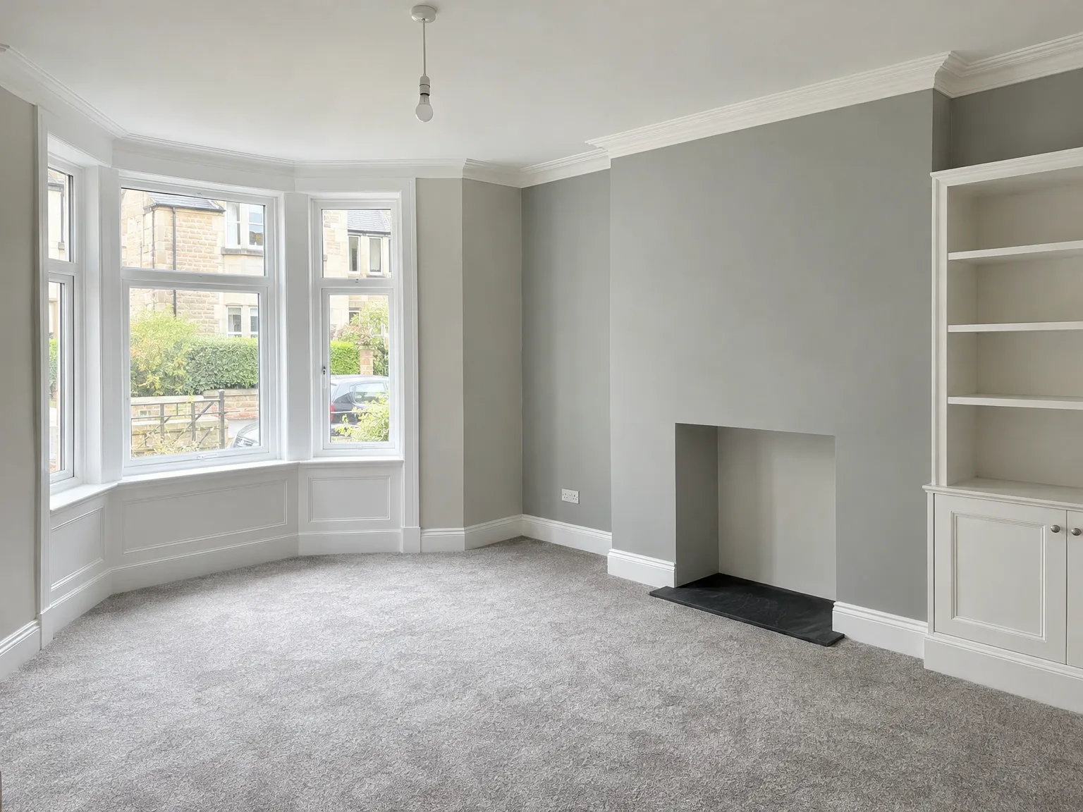 Finished interior with bay windows, grey walls, white woodwork and fitted shelving