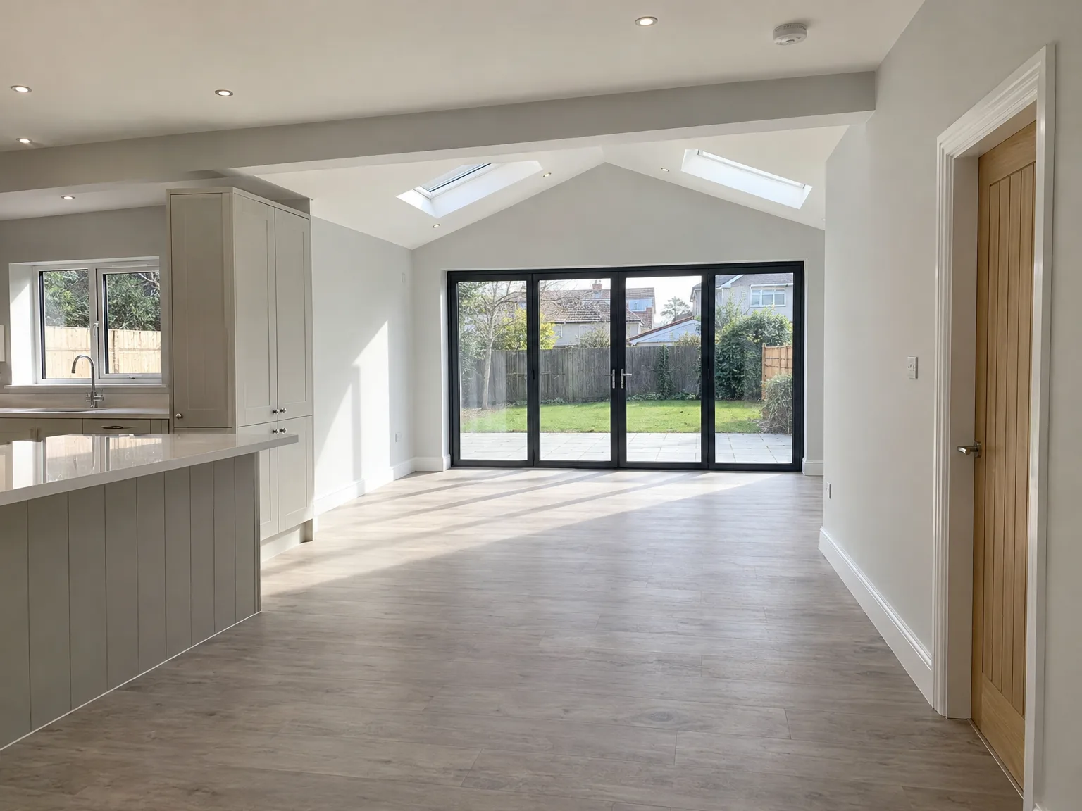 Light-filled converted loft space with modern kitchen, garden doors and vaulted ceiling with skylights