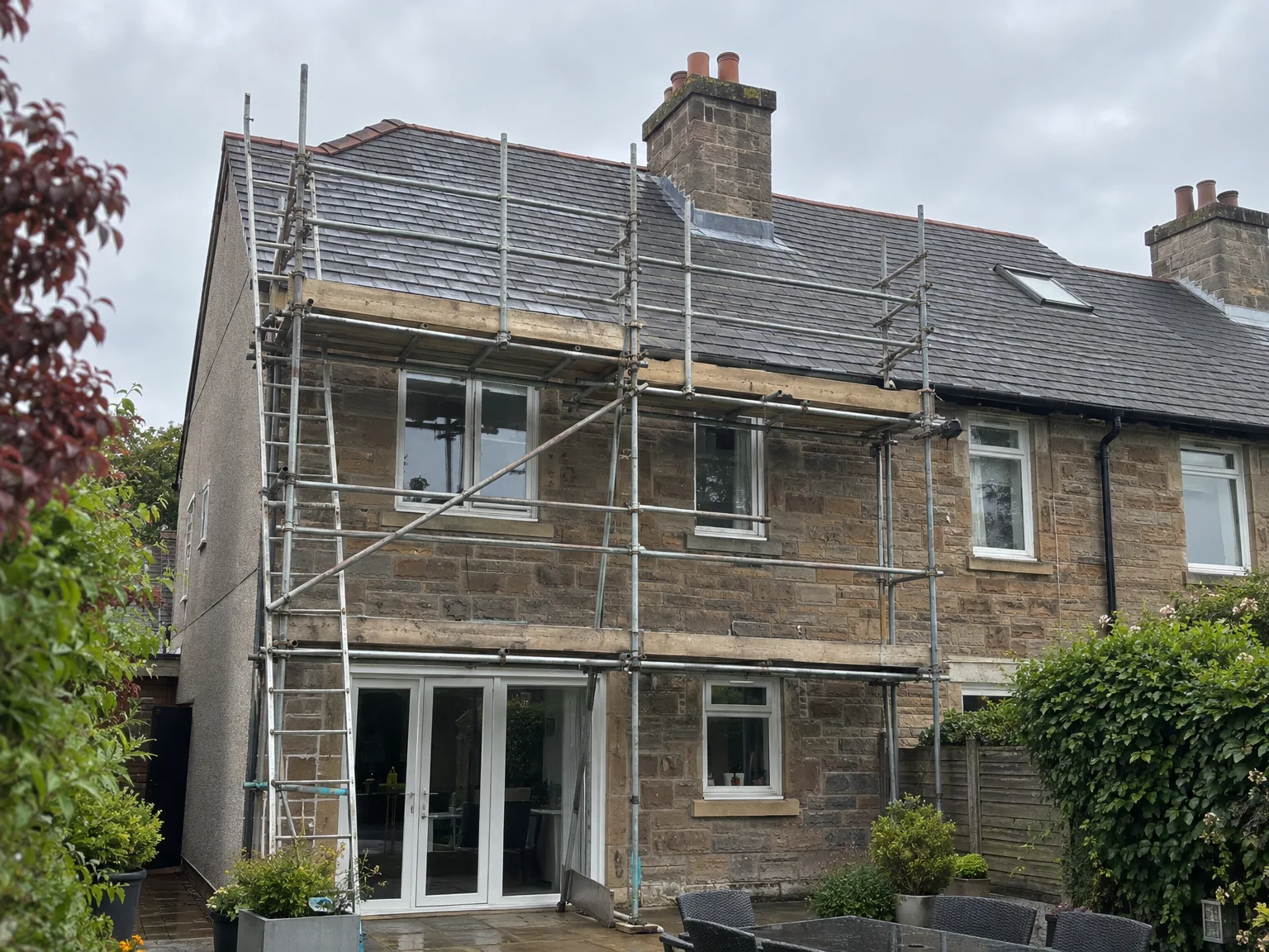 Stone house with new roof and scaffolding during home renovation