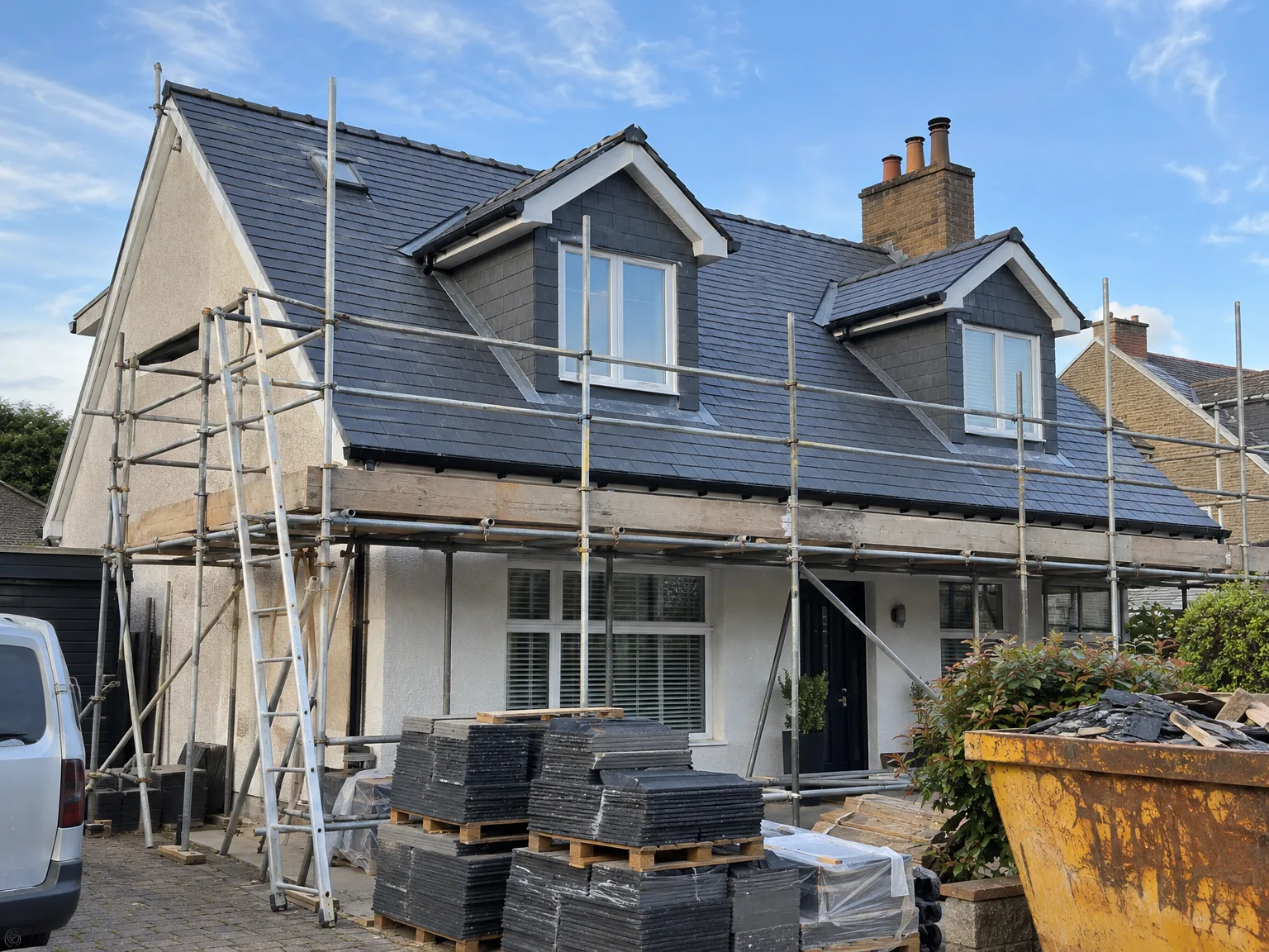 New slate roof and dormer windows during house renovation with scaffolding