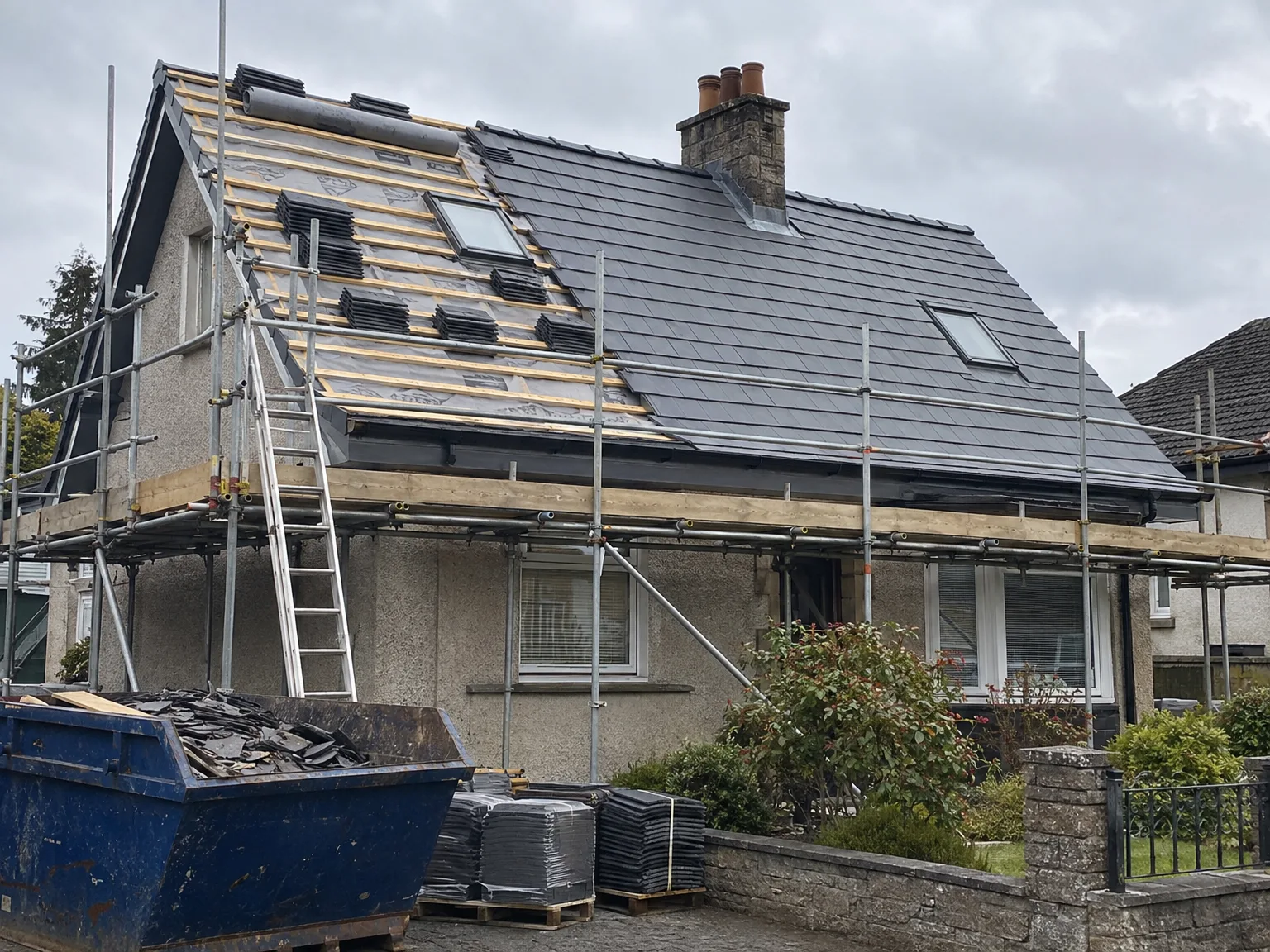 Roof replacement in progress with new slate tiling being installed on residential home with timber framework