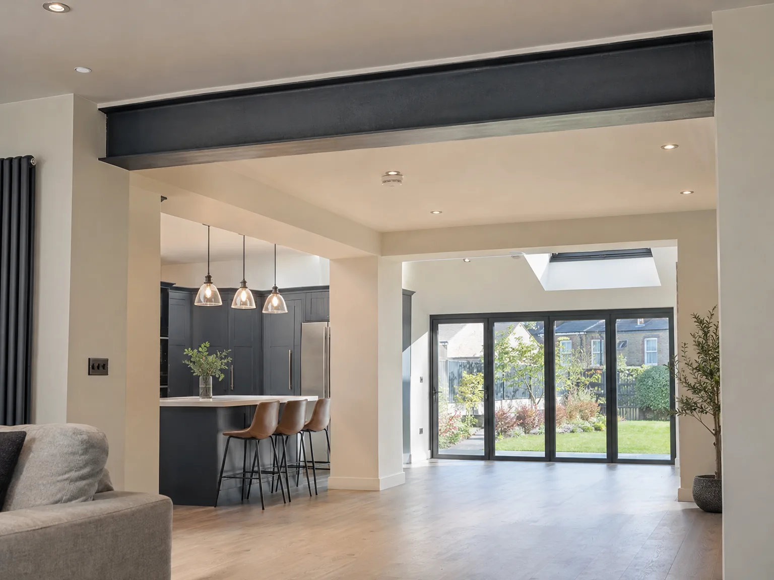 Contemporary open-plan interior with kitchen island, fitted cabinetry, and garden doors